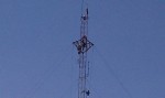 Tower workers painting torque arms on 320 foot guyed tower