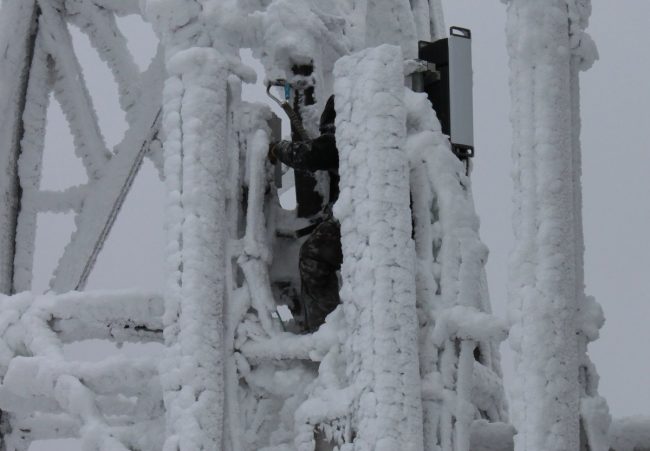 Tower climber working on ice encrusted towe